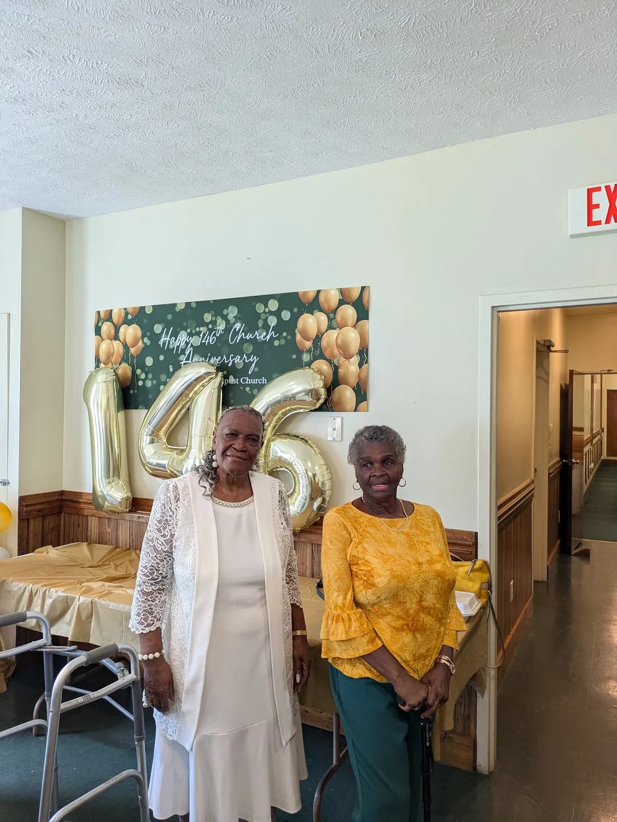 Two members dressed in white and yellow at the 146th anniversary