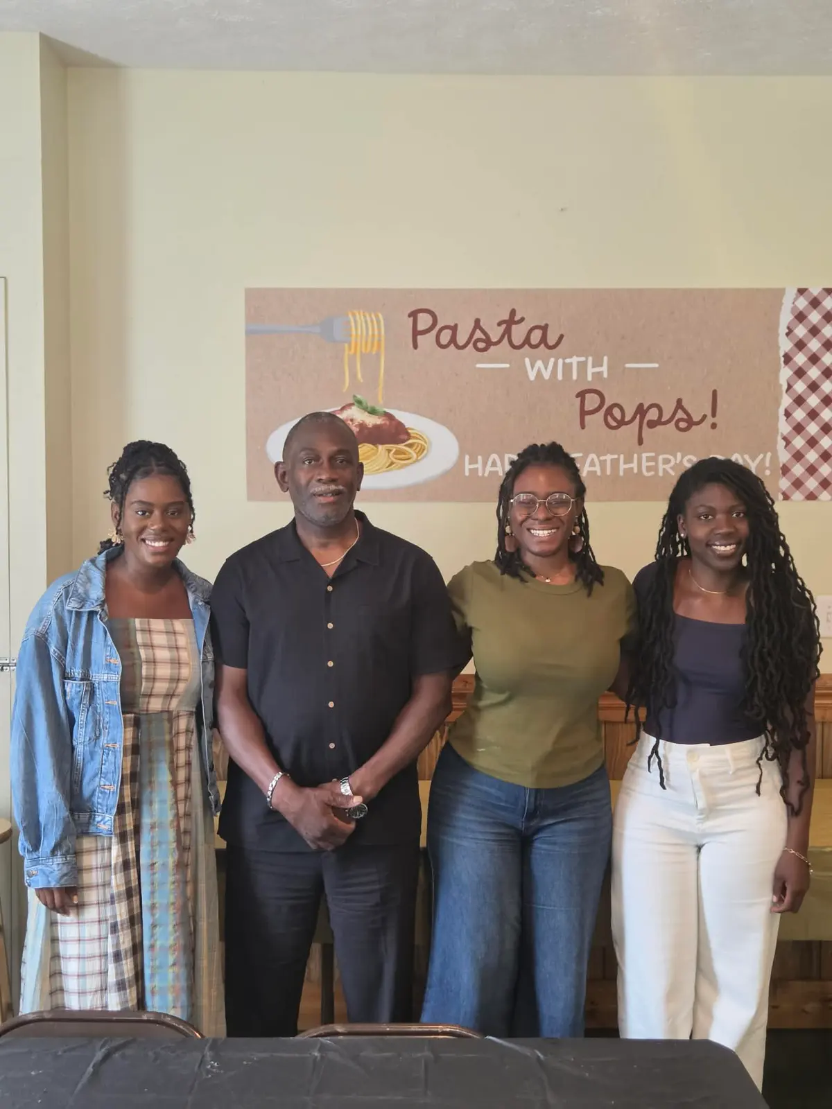 A man and three young women posing at the Father's Day celebration