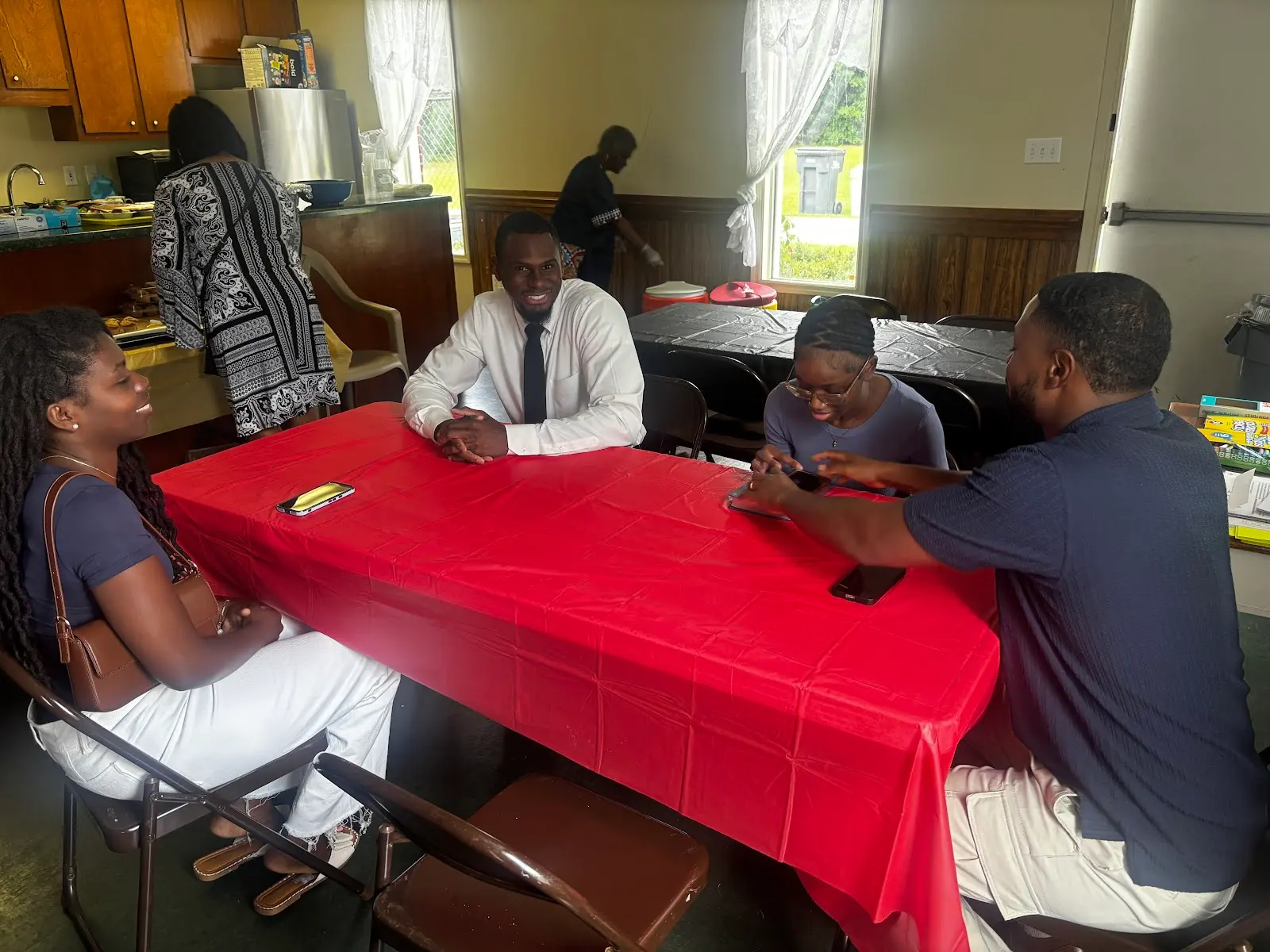 Members sharing a meal at red-clothed tables on Father's Day