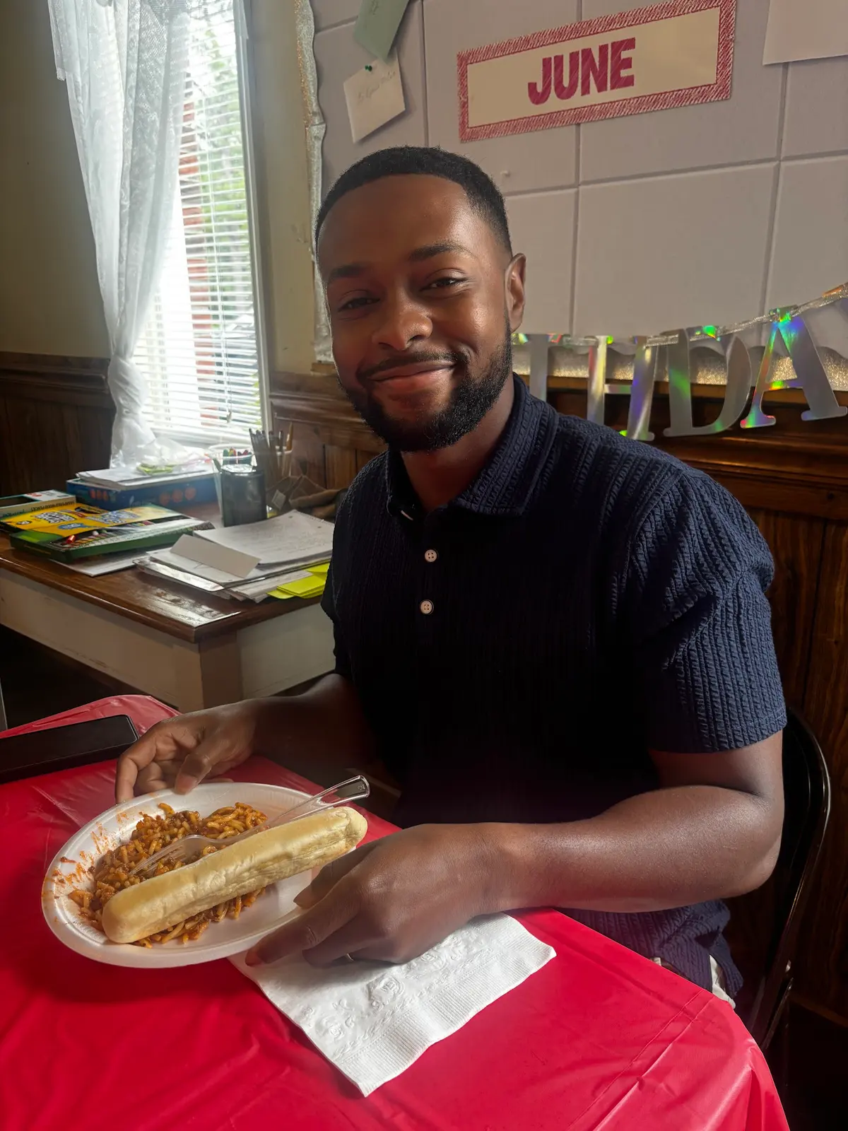 A young man smiling with his plate at the Father's Day lunch