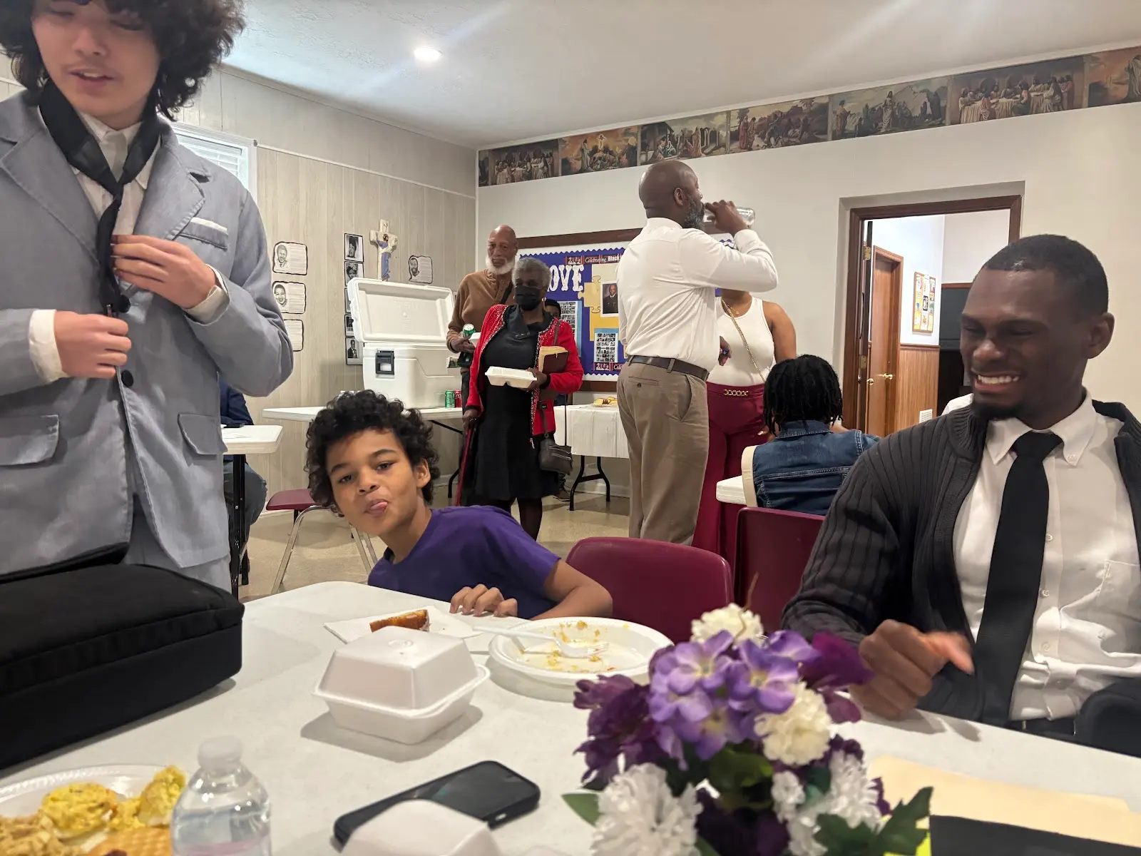 A member smiling at a fellowship meal