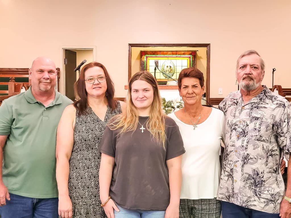 Smiling church members standing together in the sanctuary by the pulpit